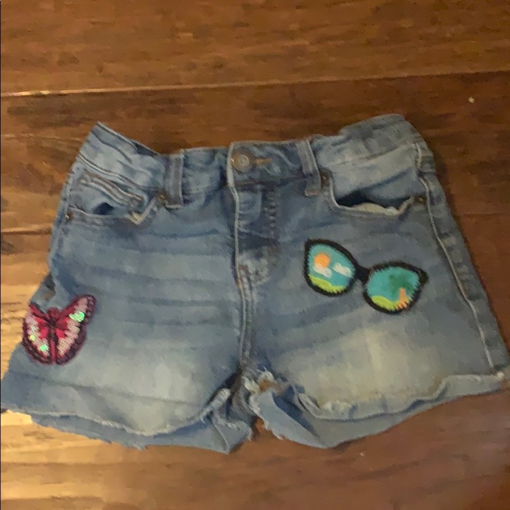 It is denim shorts with to patches that are on it